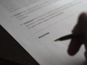 A homeowner signs a contract with the help of a real estate lawyer. 